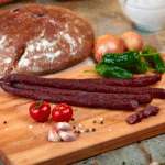 hirschbeisser auf einem holzbrett mit tomaten scharlotten zwiebeln und brot