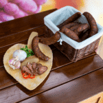 paprikawurzen in einem holzkörbchen und auf einem Holzbrett ganz und aufgeschnitten