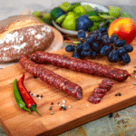 Trüffelsalami auf einem Frühstücksbrett mit Weintrauben und Brot