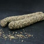 Tiroler Kaminwurzen bzw. Bergwurzen mit Pfeffermantel von Almgold offen dekorativ auf einer Schieferplatte präsentiert