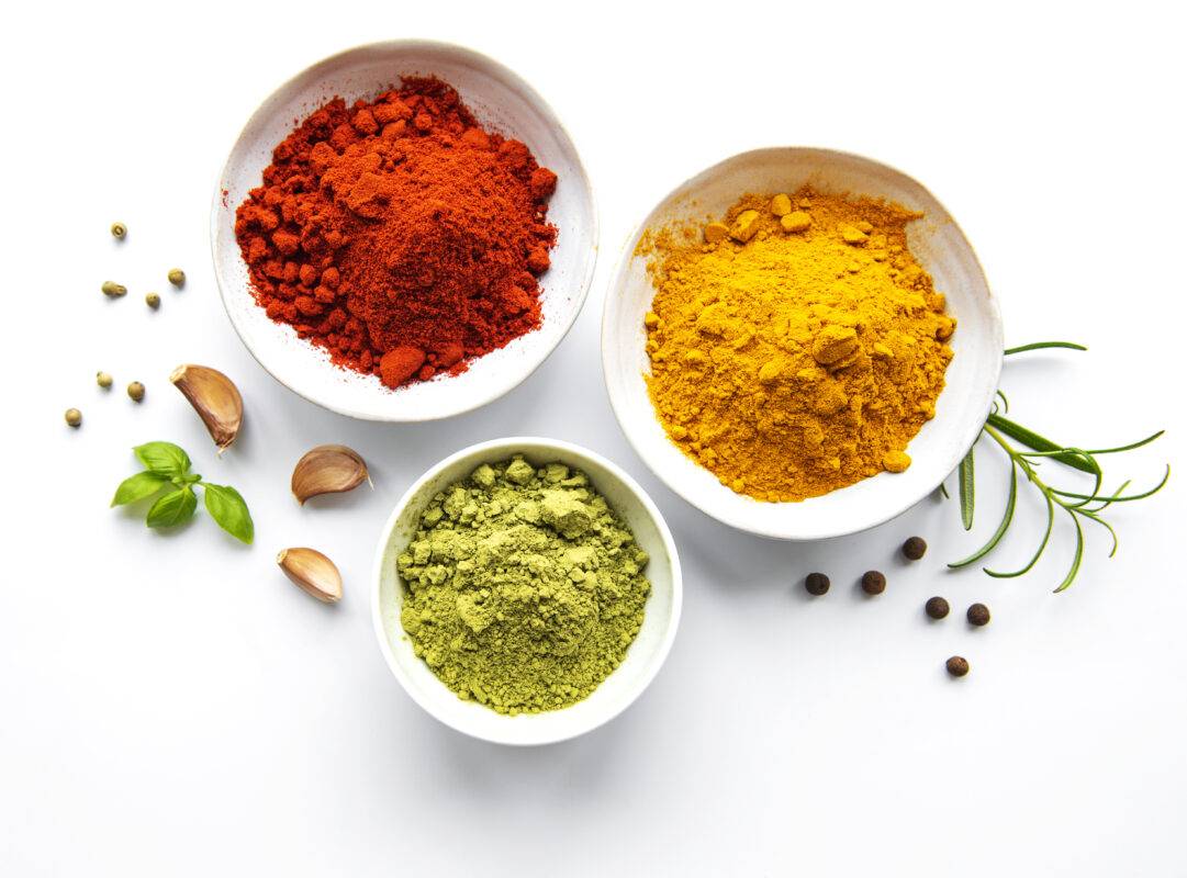 rotes, gelbes und grünes Curry in weißen Schalen und Deko